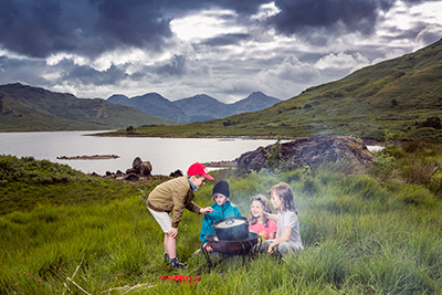 children cooking pot of nettle soup