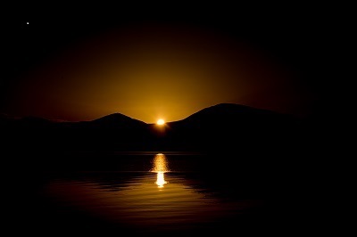 sun setting between two hills